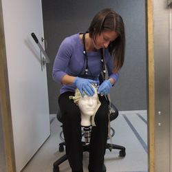 Cheryl Dickter, an associate professor of psychology, applies electrodes onto a cap inside the EEG Lab. Photo by Joseph McClain